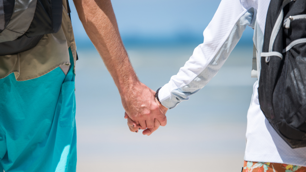 Mann und Frau Händchen haltend am Strand